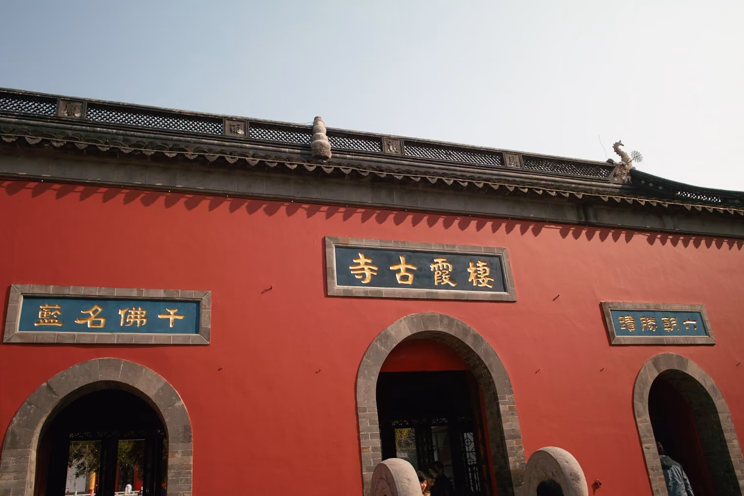 Red entrance wall and arched gates at Qixia Temple in Nanjing