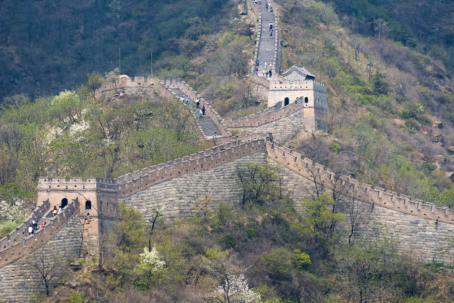 Watchtowers and the Great Wall winding through wooded hills at Mutianyu, Beijing, China