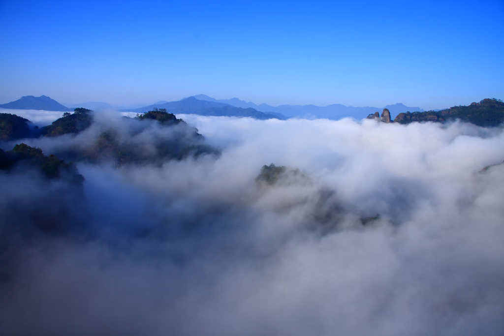 Sandstone peaks emerging through cloud in the Wuyi Mountains